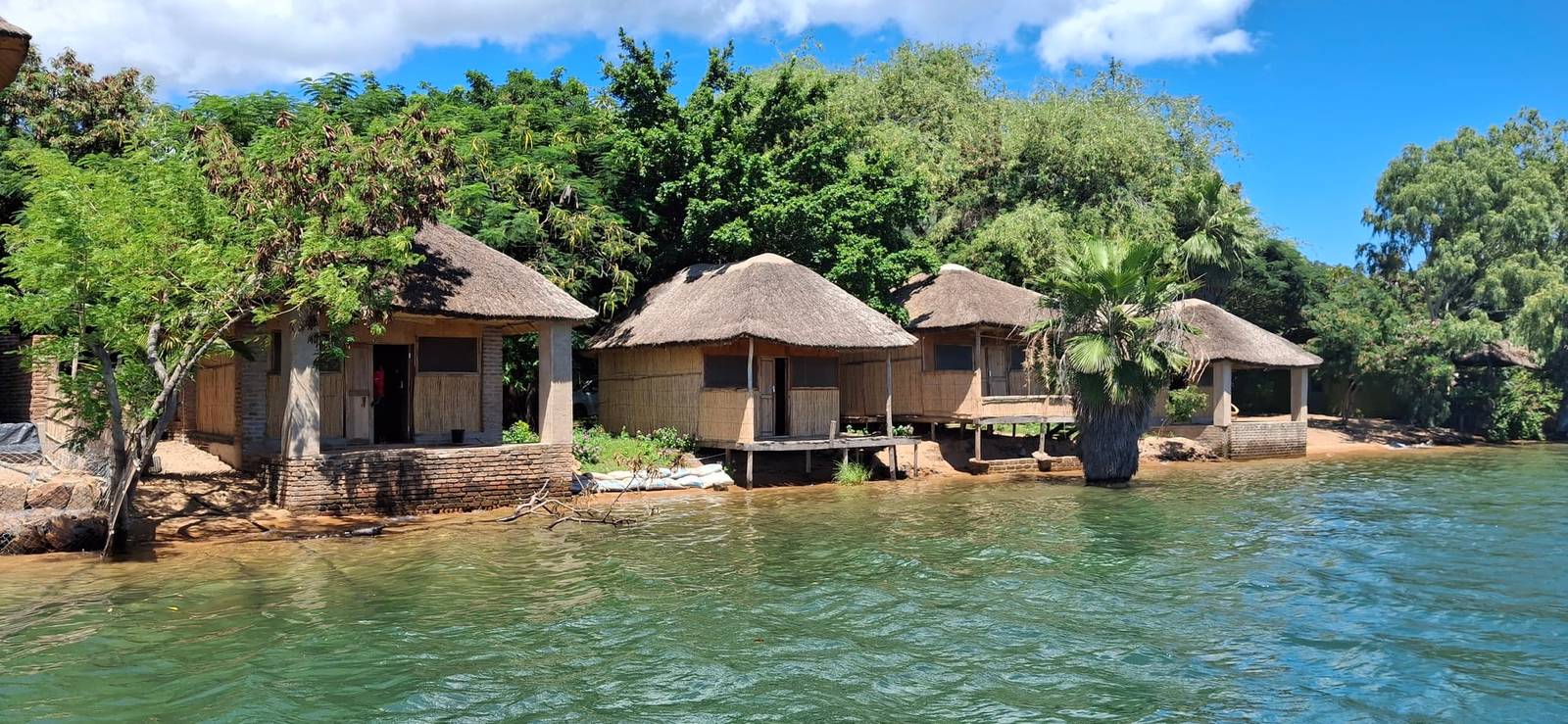 Thatched lakefront chalets at Anake Lodge seen from out on Lake Malawi